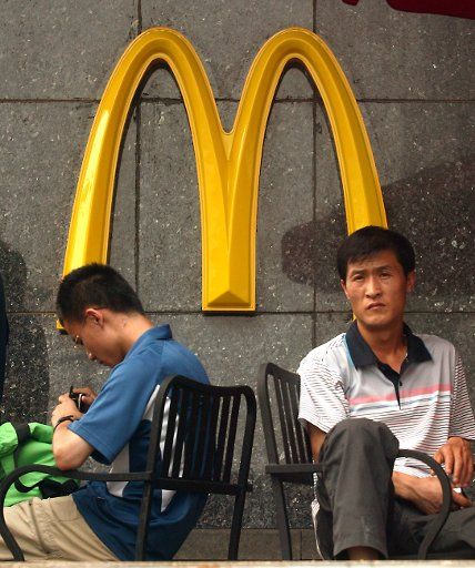Chinese men take a beak at a McDonalds on a busy shopping street in Beijing July 25 2008. (UPI Photo\/Stephen Shaver)