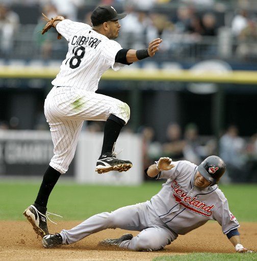 Chicago White Sox shortstop Orlando Cabrera (L) leaps over Cleveland Indians\