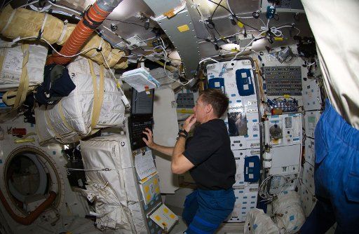 NASA Astronaut Chris Ferguson STS-126 commander uses a computer on the middeck of Space Shuttle Endeavour while docked with the International Space Station on November 19 2008. (UPI Photo\/NASA)
