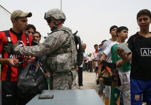 Soccer fans line up at a check point before a friendly game between a local Iraqi soccer team and a combined United States\/Iraqi military team at the Shaab Stadium in Baghdad on May 22 2009. (UPI Photo\/Ali Jasim)