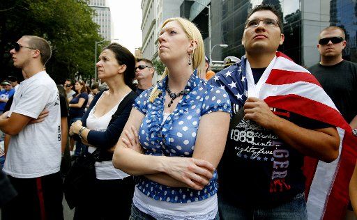 Lindsey Mayes center and Rodrigo Rosiles second right of Chicago listen to the reading of the names of victims of the 9\/11 attacks while gathered outside of Ground Zero as the tenth anniversary of September 11th is observed on September 11 ...