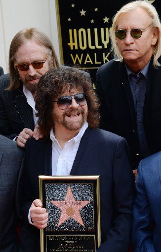 Songwriter, singer, producer and rock artist holds a replica flanked by musicians Tom Petty (L) and Joe Walsh during an unveiling ceremony honoring him with the 2,548th star on the Hollywood Walk of Fame in Los Angeles on April 23, 2015. Photo by ...
