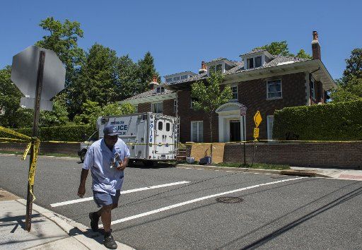 Mailman continues his route as police continue to inspect the $5 million house in the fashionable Northwest district of Washington, DC on May 23, 2015, where four people were brutally murdered after an apparent ransom was paid on May 14, 2015. ...