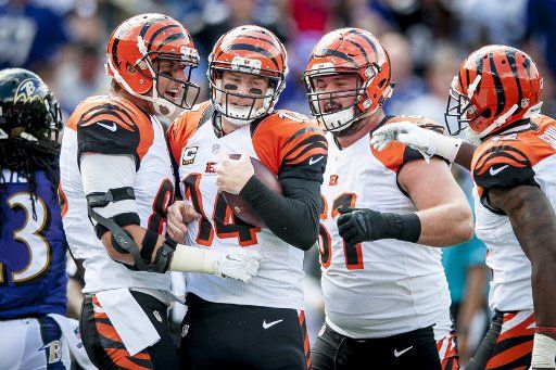 Teammates surround Cincinatti Bengal quarterback, Andy Dalton, after he scored touchdown during the first quarter against the Baltimore Ravens at M&M Bank Stadium on September 27, 2015 in Baltimore, Maryland. Photo by Pete Marovich\/