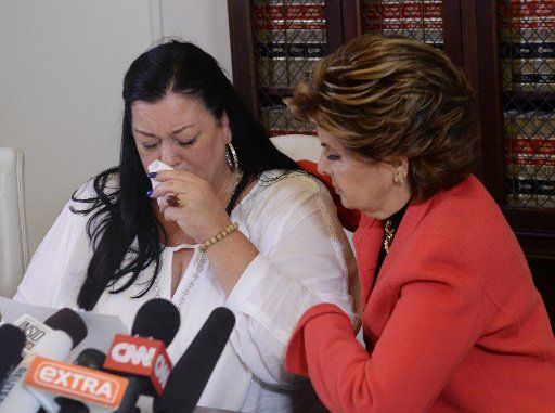 Pamela Abeyta reacts during a news conference with three new alleged sexual assault victims of comedian Bill Cosby while attorney Gloria Allred comforts her in Los Angeles on September 30, 2015. Cosby has been accused of sexual assault by over 50 ...