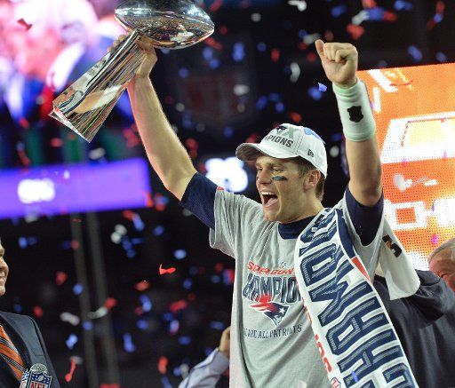 New England Patriots Tom Brady holds up the Vince Lombardi Trophy next to Head Coach Bill Belichick (R) after defeating the Seattle Seahawks 28-24 to win Super Bowl XLIX at University of Phoenix Stadium in Glendale, Arizona, February 1, 2015. Photo ...