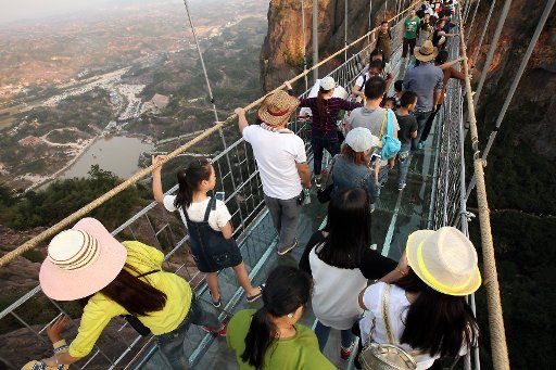 Hundreds of Chinese tourists visit a recently completed glass-bottomed bridge nearly 600 yards above a sheer drop in Shiniuzhai Park in northern Hunan Province, China, on October 24, 2015. Haohan Qiao, or Brave Man\