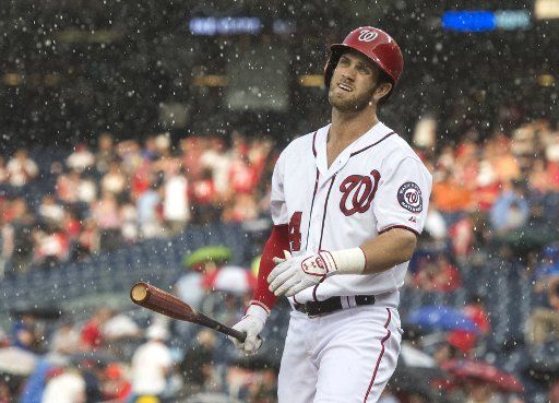 Washington Nationals Bryce Harper attempts to bat as heavy rain falls in the first inning against the Cincinnati Reds at Nationals Park in Washington, D.C. on July 6, 2015. Photo by Kevin Dietsch\/