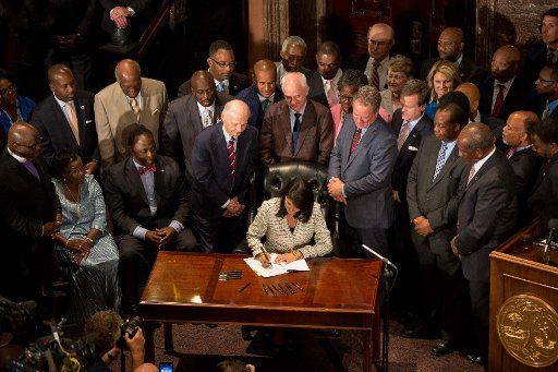 South Carolina Gov. Nikki Haley signs S.897 into law at the State House in Columbia, South Carolina on July 9, 2015. The bill allows the removal of the Confederate flag that flies on the State House grounds. This comes in the wake of the nine people ...