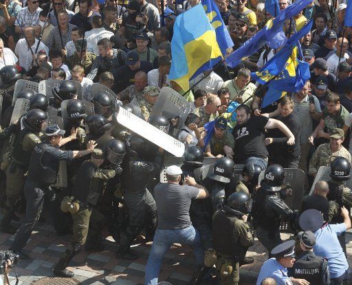 Ukrainian riot police and protesters clash outside the parliament in Kiev on August 31, 2015. Hundreds of people gathered in front of the parliament to protest against an approved constitutional amendment on decentralization to separatist regions. ...