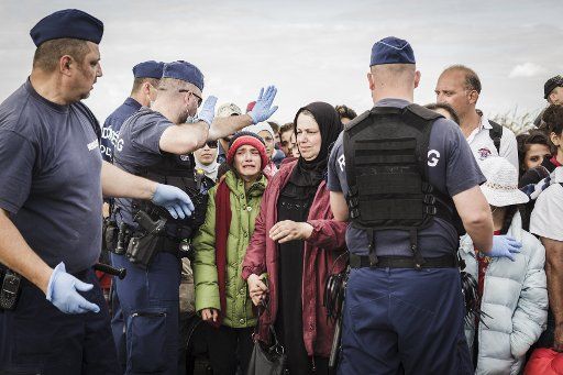 A Syrian girl cries as Hungarian police try to direct refugees near the Reszke crossing in Hungary on the border with Serbia on September 8, 2015. Syrian and other refugees are sleeping for days in the fields waiting their chance to get a bus that ...