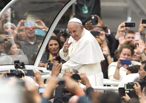 Pope Francis waves to the crowd as he arrives for Mass on the Benjamin Franklin Parkway concluding his three-city U.S. visit in Philadelphia, September 27, 2015. An estimated 1,000,000 people have come to Philadelphia to see the Pope. Photo by Kevin ...