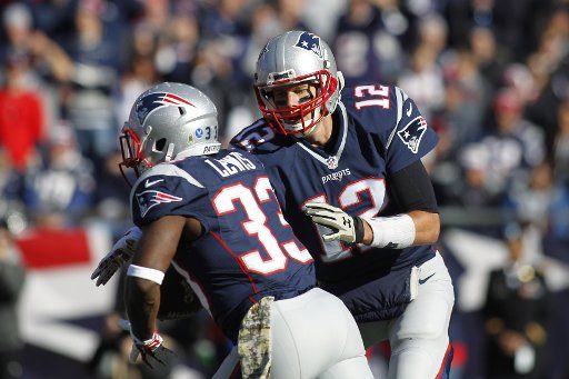 New England Patriots quarterbacks Tom Brady (12) hands off to running back Dion Lewis (33) in the first quarter against the Washington Redskins at Gillette Stadium in Foxborough, Massachusetts on November 8, 2015. Photo by Matthew Healey\/