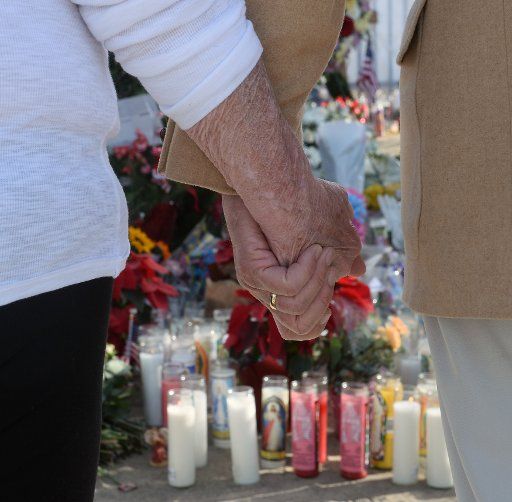 People pay their respects at a makeshift memorial near the Inland Regional Center in San Bernardino, California on December 6, 2015. The FBI continues to investigate the San Bernardino mass shooting that left 14 people dead and another 21 injured ...