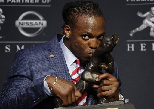 Alabama running back Derrick Henry kisses the Heisman Trophy at a press conference after winning of the 2015 Heisman Trophy Award at the Marriott Marquis in New York City on December 12, 2015. Stanford running back Christian McCaffrey and Clemson ...