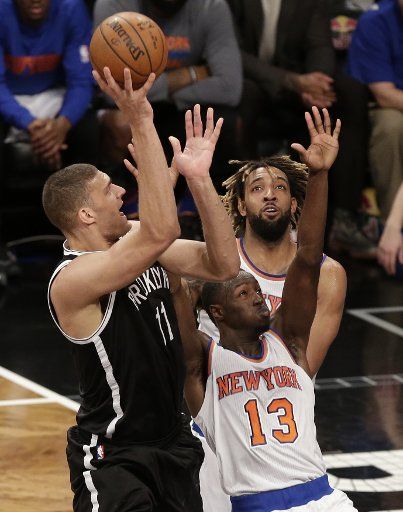 New York Knicks Derrick Williams watches Brooklyn Nets Brook Lopez shoot the basketball in the 4th quarter at Barclays Center in New York City on January 13, 2016. The Nets defeated the Knicks 108- 104. Photo by John Angelillo\/
