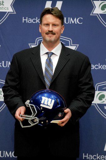 New York Giants new head coach Ben McAdoo holds a Giants helmet at his introduction press conference at MetLife Stadium in East Rutherford, New Jersey on January 15, 2016. McAdoo replaces 2-time Super Bowl winning coach Tom Coughlin after 12 years ...