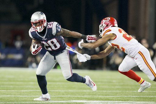 New England Patriots running back James White (28) slips a tackle from Kansas City Chiefs cornerback Marcus Peters (22) in the third quarter of the AFC Divisional Playoff game at Gillette Stadium in Foxborough, Massachusetts on January 16, 2016. The ...
