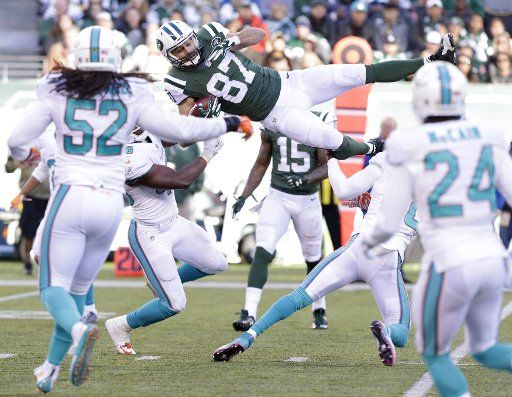 Miami Dolphins Reshad Jones tackles New York Jets Eric Decker leaps for extra yards on a 16 yards reception in the second quarter at MetLife Stadium in East Rutherford, New Jersey on November 29, 2015. Photo by John Angelillo\/