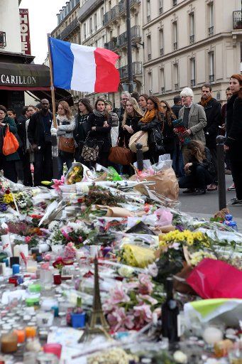 People mourn in front of Le Carillon bistro and Le Petit Cambodge restaurant on November 16, 2015. More than one hundred people were killed and many more wounded when gunmen opened fire at multiple locations across the French capital during a series ...