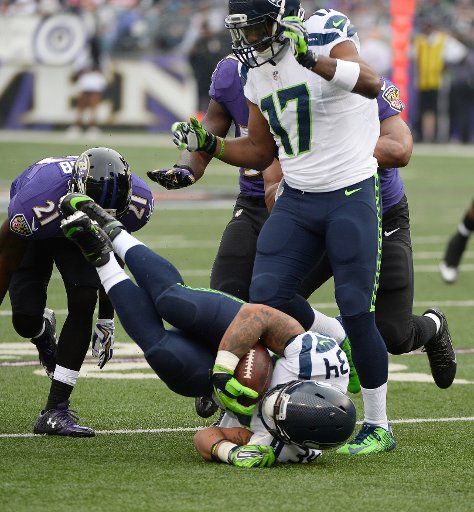 Seattle Seahawks running back Thomas Rawls (34) dives onto his shoulder as Baltimore Ravens\