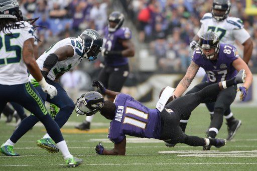 Baltimore Ravens wide receiver Kamar Aiken (11) loses his helmet after Seattle Seahawks safety Kam Chancellor (31) blocks a pass to Aiken during the first half of their NFL game at M&T Bank Stadium in Baltimore, Maryland, December 13, 2015. Photo by ...
