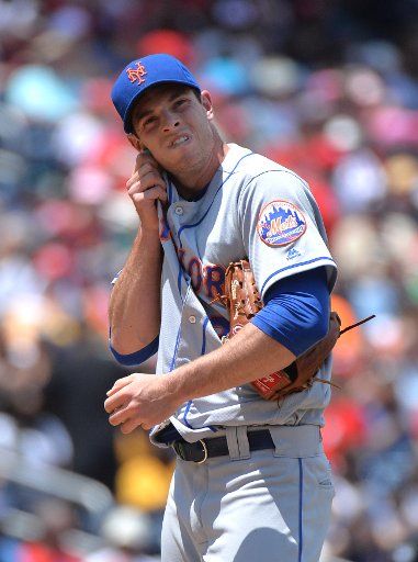 New York Mets starting pitcher Steven Matz (32) pitches wipes his face after walking Washington Nationals\