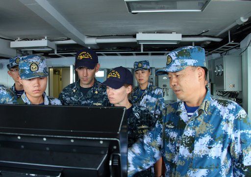 China and U.S. Officers naval officers discuss a gunnery exercise aboard the Chinese navy guided-missile frigate Hengshui (572) during Rim of the Pacific 2016 on July 21, 2016. Photo by PLA Navy\/