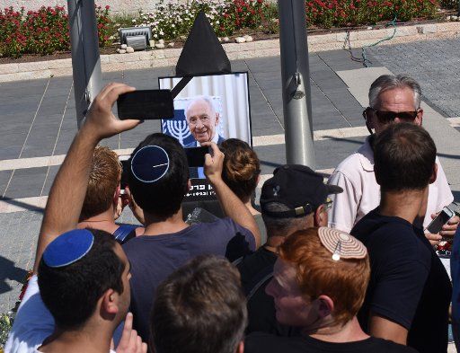 Israelis take photos of a portrait of Israeli President Shimon Peres as he lies in state in the plaza of the Israeli Knesset, in Jerusalem, Israel, September 29, 2016. The veteran Israeli leader died on September 28 at the age of 93, after suffering ...