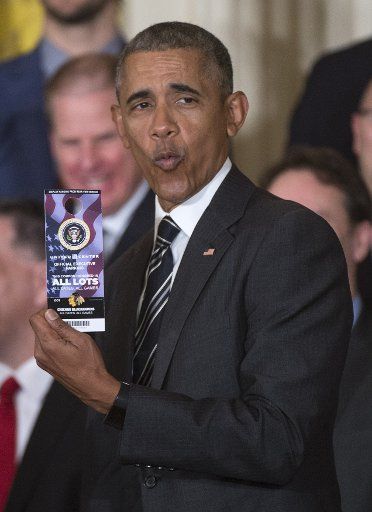 President Barack Obama shows off an "all-access" parking pass to the United Center given to him by the 2015 NHL Champions Chicago Blackhawks during an event where he welcomed the team the White House in Washington, Washington, DC on February 18, ...