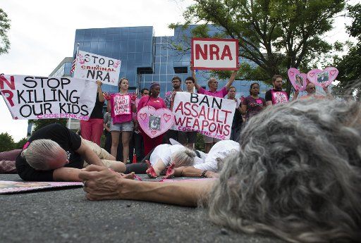 Protesters take part in a die-in to demonstrate against the shooting in Orlando and call for a ban on assault weapons, outside the NRA headquarters in Fairfax, Virginia, on June 21, 2016. Photo by Molly Riley\/