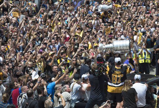 Fans cheer as Pittsburgh Penguins team captain and playoff MVP Sidney Crosby holds the Stanley Cup during the Penguins\