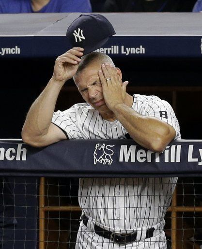 New York Yankees manager Joe Girardi takes ofF his cap in the dug out while watching the game in the 8th inning against the New York Mets at Yankee Stadium in New York City on August 3, 2016. Photo by John Angelillo\/
