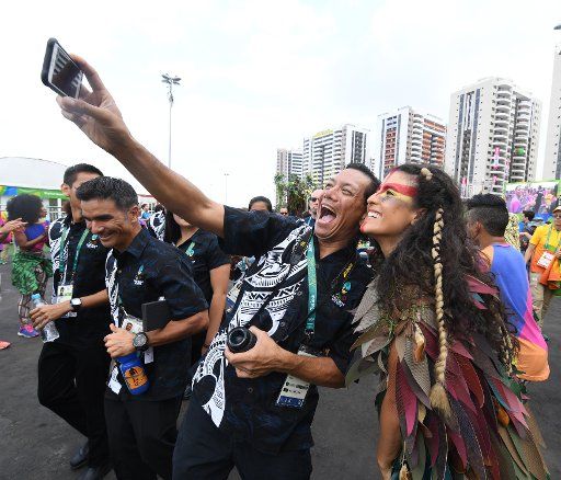 An Olympian from Guam takes a selfie with a Brazilian dancer during welcoming ceremonies at the Athletes Village in Rio de Janeiro, Brazil on August 2, 2016. It is three days before the opening ceremony for the 2018 Olympics. Photo by Terry Schmitt\/...