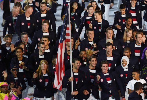 Michael Phelps holds the American flag as he leads the United States in the arena at the Opening Ceremony of the 2016 Rio Summer Olympics begins in Rio de Janeiro, Brazil on August 5, 2016. Photo by Terry Schmitt\/