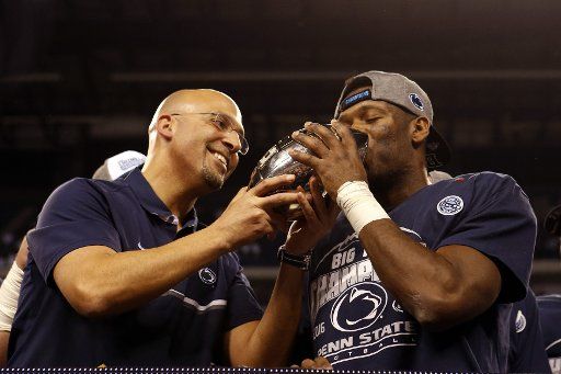 Penn State Nittany Lions head coach James Franklin has Malik Golden kiss the trophy after the defeated the Wisconsin Badgers 38-31 in the 2016 Big Ten Football Championship Game in Indianapolis on December 3, 2016. Photo by John Sommers II\/