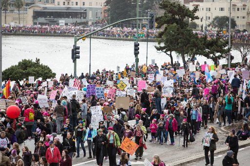 Protesters march around Lake Merritt in the Women\