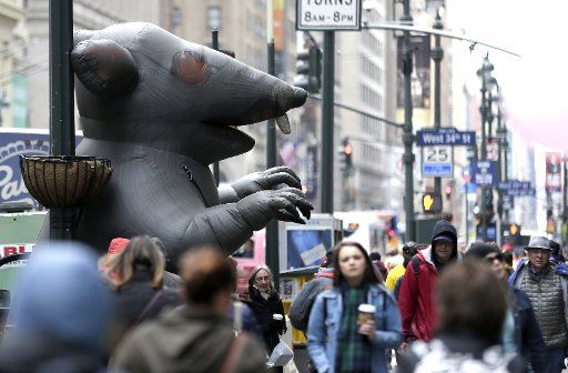 Pedestrians walk past a giant inflatable rat on the sidewalks along Seventh Avenue in New York City on March 24, 2017. Photo by John Angelillo\/