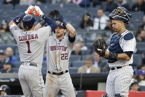 New York Yankees Brian McCann stands at the plate as Houston Astros Carlos Correa celebrates with Josh Reddick after hitting a 2-run home run in the first inning at Yankee Stadium in New York City on May 11, 2017. Photo by John Angelillo\/