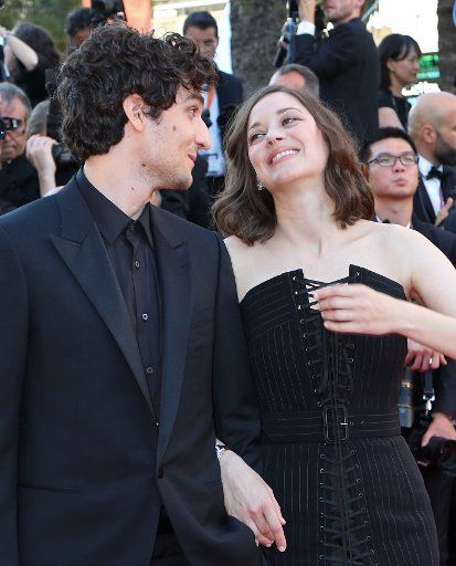 Louis Garrel (L) and Marion Cotillard arrive on the red carpet before the screening of the film "Les Fantomes d\