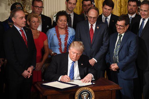 U.S. President Donald Trump signs the "VA Accountability and Whistleblower Protection Act" during an event in the East Room of the White House in Washington, DC on June 23, 2017. The act is designed to make it easier to fire problem employees at ...