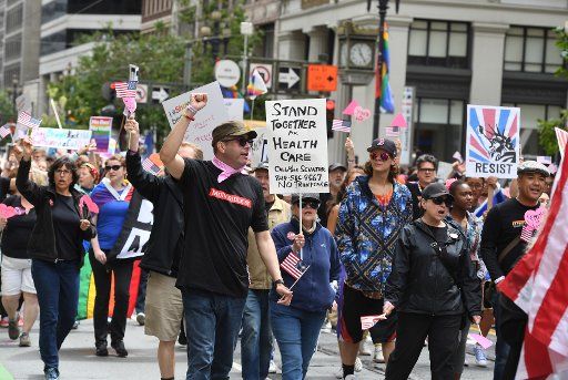 Political signs are carried in the annual LGBT Pride Parade in San Francisco on June 25, 2017. Political action, gay pride and corporate advertising were themes as tens of thousands participated. Photo by Terry Schmitt\/