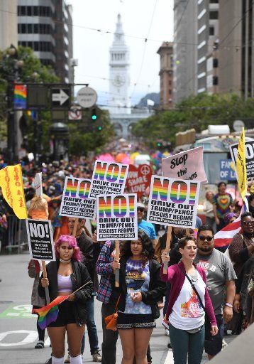 Political signs are carried in the annual LGBT Pride Parade in San Francisco on June 25, 2017. Political action, gay pride and corporate advertising were themes as tens of thousands participated. Photo by Terry Schmitt\/