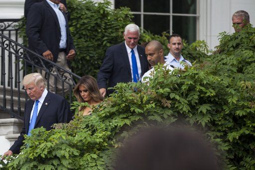 U.S. President Donald Trump, first lady Melania Trump and Vice President Mike Pence make their way down from the Truman Balcony on July 4, 2017 in Washington, DC. The president was hosting a picnic for military families for the July 4 holiday. ...