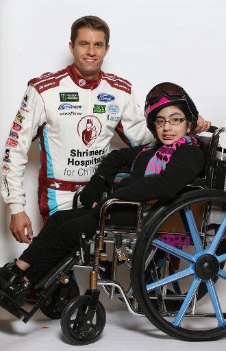 NASCAR driver and ambassador David Ragan joins Fatima Valadez (13) during the taping of Shriners Hospitals network holiday commercials in St. Louis on August 8, 2017. Photo by Bill Greenblatt\/