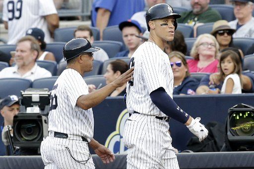 New York Yankees first base coach Tony Pena puts his arm on the back of Aaron Judge who walks to the dug out after popping out in the 7th inning against the Boston Red Sox at Yankee Stadium in New York City on August 12, 2017. Photo by John ...