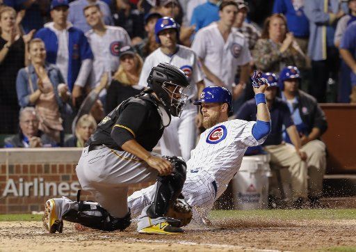 Chicago Cubs Ben Zobrist (R) scores against the Pittsburgh Pirates in the eighth inning at Wrigley Field on August 28, 2017 in Chicago. Photo by Kamil Krzaczynski\/