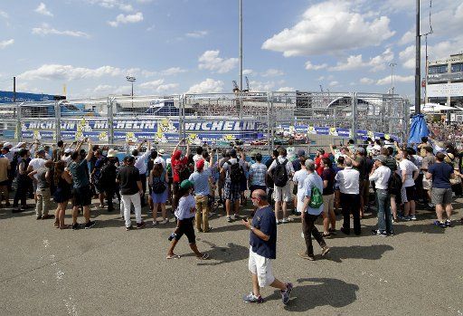 Fans watch competing cars race around the track at the Formula E all-electric New City ePrix on July 15, 2017 in New York City. Saturday and Sunday the Brooklyn waterfront with a view of the Statue of Liberty was transformed into a racetrack for the ...