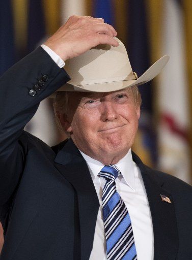 President Donald Trump puts on a Stetson cowboy hat during a Made in America product showcase on Made in America day at the White House in Washington, D.C. on July 17, 2017. Trump hosted manufacturers and corporations for all 50 states to highlight ...