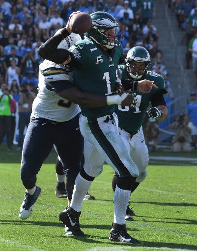 Philadelphia Eagles quarterback Carson Wentz (11) throws the ball while being tackled by Los Angeles Chargers Corey Liuget during fourth quarter action at StubHub Center in Carson, California on October 1, 2017. Photo by Jon SooHoo\/